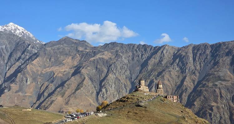 Gergeti Drievuldigheidskirk gelegen op een bergkam voor ruige Kaukasus-toppen.