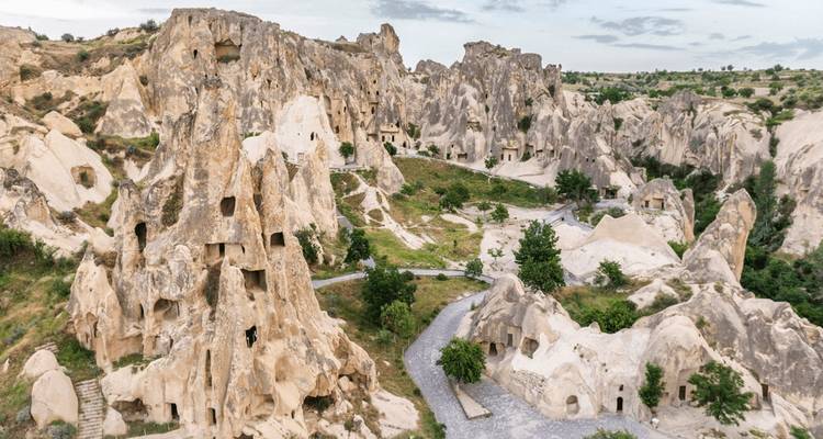 Felsige Landschaft Kappadokiens mit hohen erodierten Felsnadeln und alten Höhlenwohnungen, verbunden durch einen gewundenen Pfad