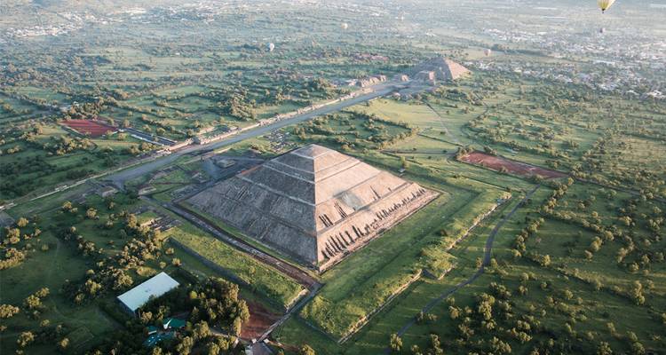 Vue aérienne en plongée de la Pyramide du Soleil de Teotihuacán et des plaines vertes environnantes.