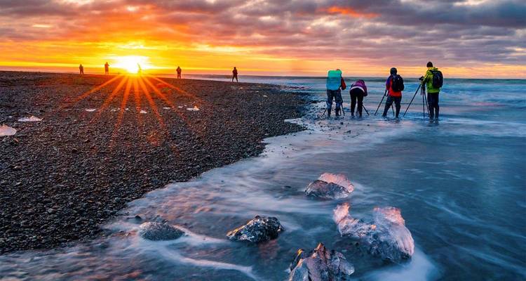 Photographers capture sunrise light sparkling over waves and ice crystals on Iceland’s Diamond Beach.