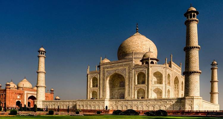 Classic postcard view of the Taj Mahal gleaming under a deep blue sky.