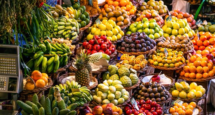 Ein lebendiger Marktstand, der von ordentlich angeordneten tropischen Früchten in allen Farben überquillt.