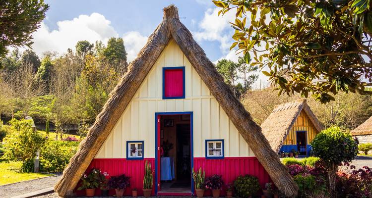 Traditionelles dreieckiges Santana-Haus mit Strohdach und farbenfroher Fassade.