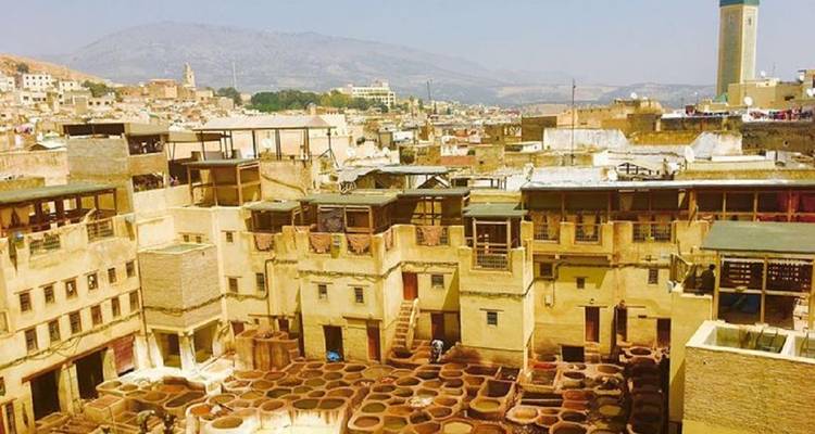 Historische leerlooierij kuilen en omliggende gebouwen gezien vanaf dak in Fes medina