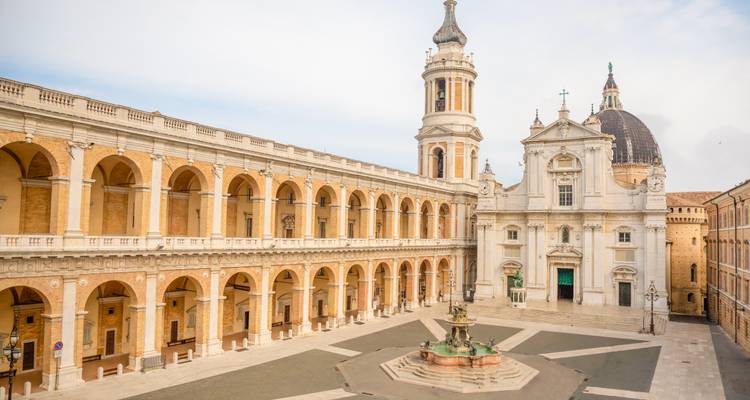 Elegant Renaissance courtyard of the Sanctuary of Loreto with central fountain.