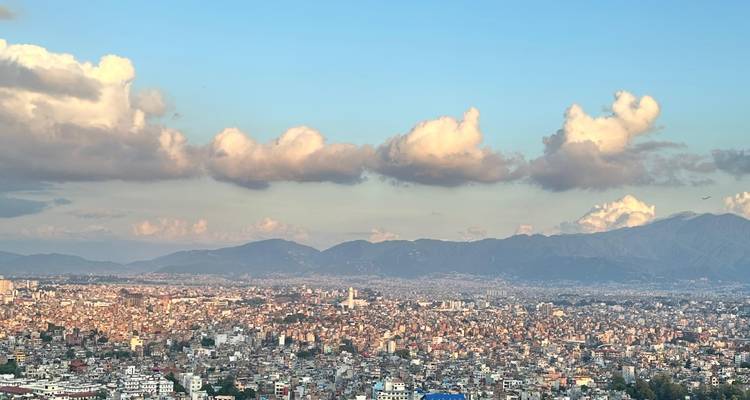 Expansive skyline of Kathmandu valley with low evening clouds and surrounding mountain ranges