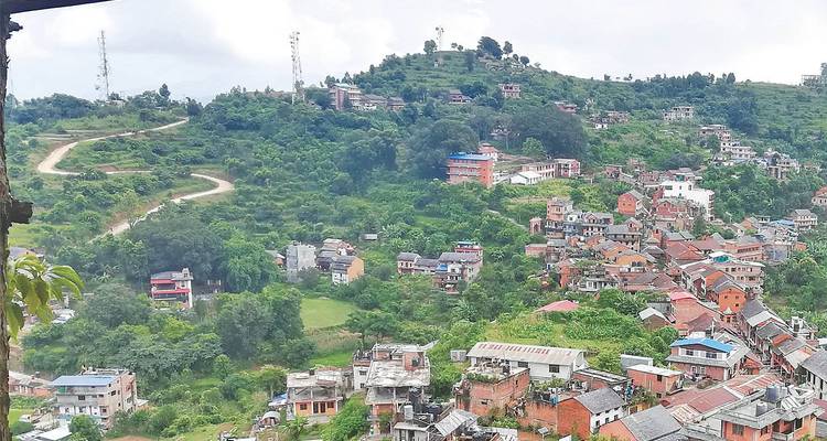 Aerial view of green hills dotted with Bandipur town’s red roofs.