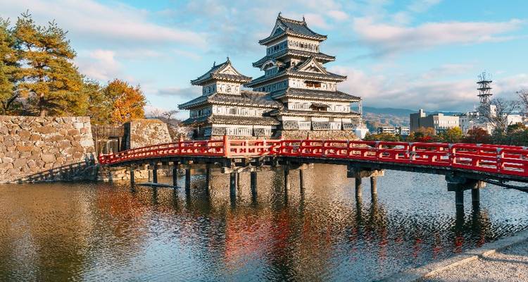 Historisch kasteel Matsumoto met rode brug weerspiegeld in de slotgracht.