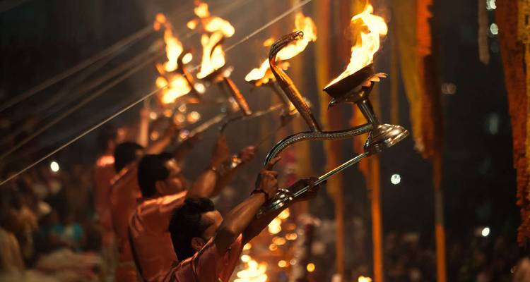 Nightly Ganga Aarti ceremony with priests raising flaming lamps along the riverbank.
