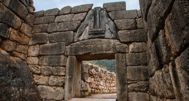 The famous Lion Gate entrance of Mycenae built from massive cyclopean stones, framing a pathway beyond.