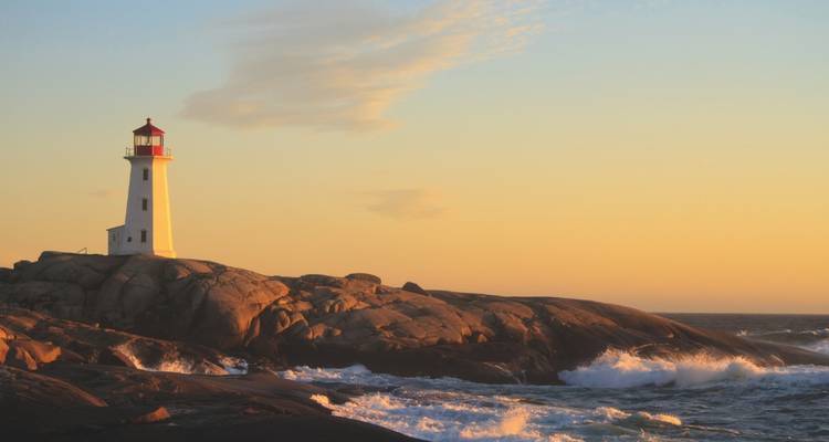 Le phare de Peggy's Cove se dresse sur le granit escarpé face aux vagues de l'Atlantique qui s'écrasent au coucher du soleil.