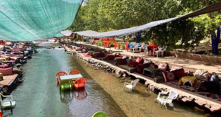Canal-like river seating with fabric canopies and bright plastic chairs.