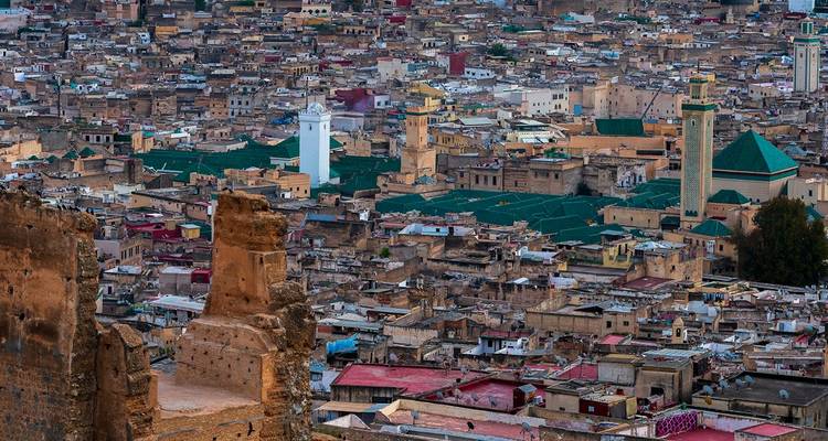 Vue panoramique sur les toits densément construits de la médina et les minarets de Fès depuis les ruines situées en montagne.