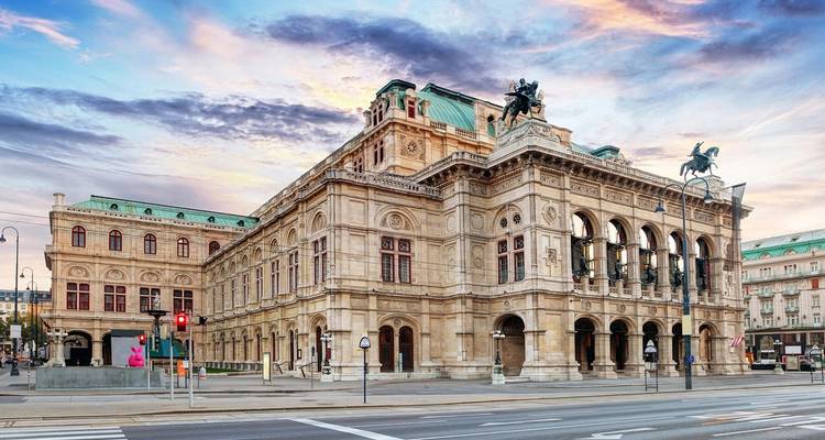 Weense Staatsopera gebaad in zonsondergangkleuren onder een dramatische hemel.