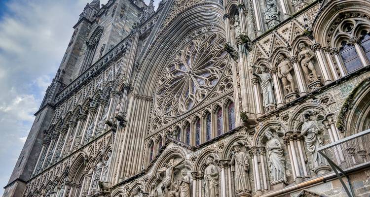 Nahaufnahme der kunstvollen gotischen Fassade des Nidarosdoms mit detaillierten Statuen und Rosettenfenster.