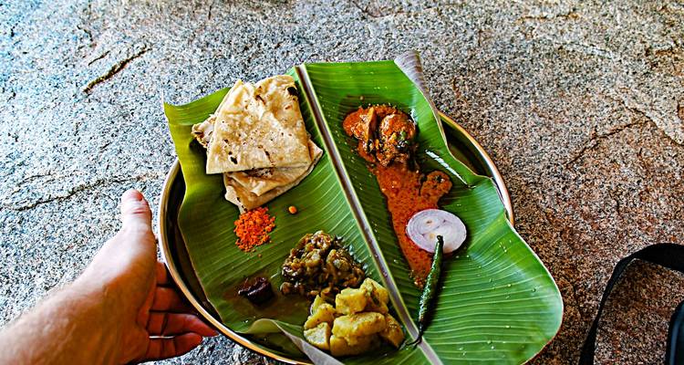 Traditional South Indian meal served on a banana leaf with assorted curries and breads.