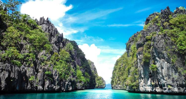 Des falaises calcaires spectaculaires s'élèvent au-dessus d'un chenal bleu cristallin à El Nido
