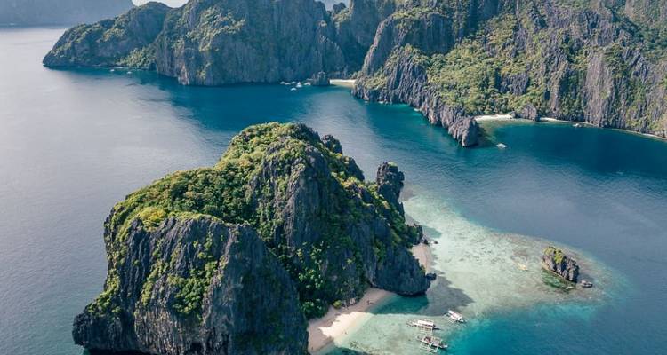 Perspective aérienne d'îles escarpées couvertes de jungle entourées d'une mer d'un bleu profond