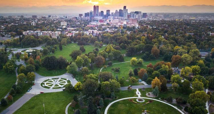 Vue aérienne au coucher de soleil sur le vaste parc urbain de Denver avec le centre-ville et les montagnes Rocheuses