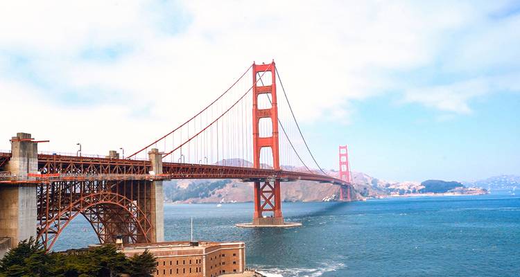 Iconic red Golden Gate Bridge spans the blue entrance to San Francisco Bay on a clear day.