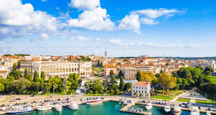 Pula amphitheater and marina shine under a bright blue Croatian sky.
