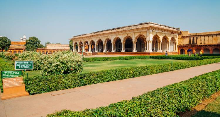 Un long hall en marbre à colonnade s'élève derrière des haies soigneusement entretenues dans l'enceinte du Fort d'Agra.