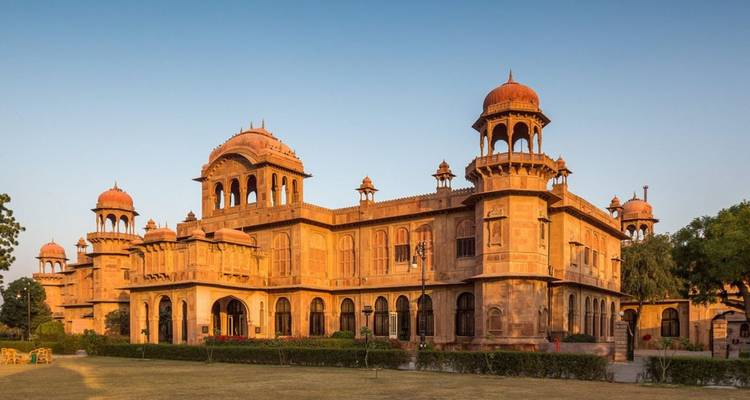 Laxmi Niwas Palace in Bikaner verlicht door warm laat middaglicht en omringd door gazons.