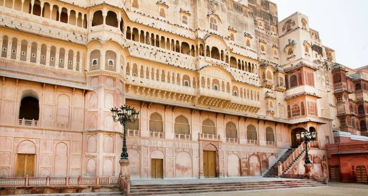 Junagarh Fort binnenpaleis met lichtroze zandstenen gevel, sierlijke ramen en trap.