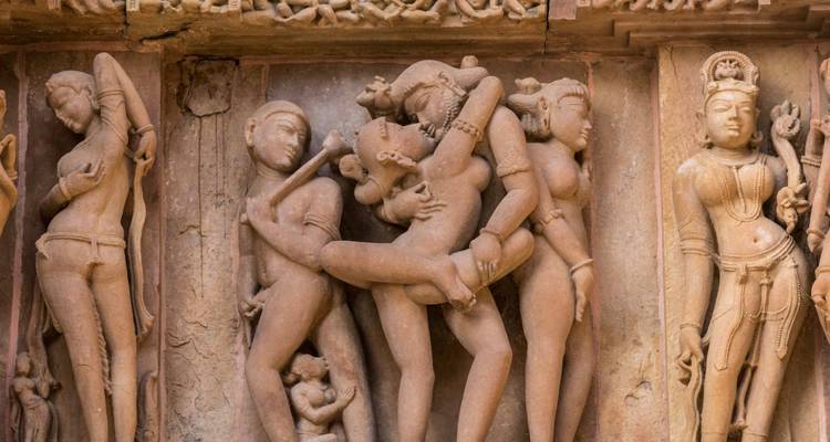 Close-up of intricately carved erotic stone sculptures at Khajuraho temple.