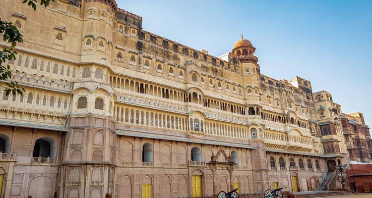 Lange zandstenen paleisfaçade met sierlijke balkons en gele deuren van Junagarh Fort