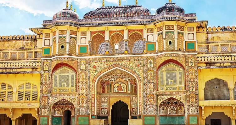 Intricately painted Ganesh Pol gateway at Amber Fort featuring rich yellow and green motifs.