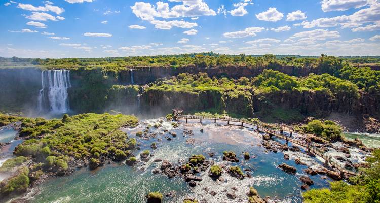 Expansive vista of Iguazu River, walkways and dense jungle with waterfalls at horizon