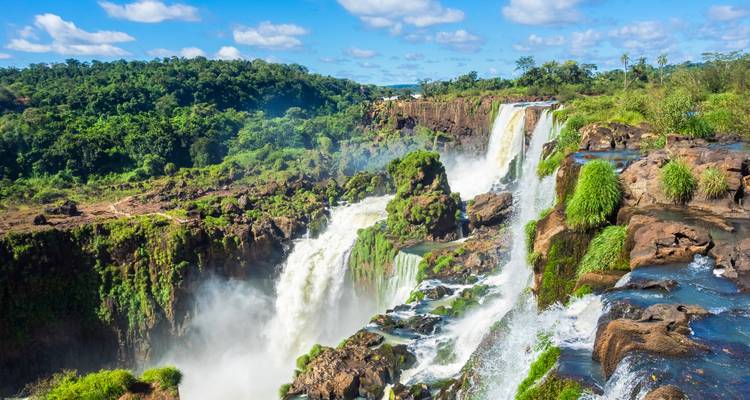 Close-up of cascading Iguazu Falls crashing over mossy cliffs into mist