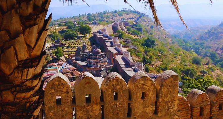 Elevated view over Kumbhalgarh Fort ramparts and surrounding Aravalli hills framed by stone battlements.
