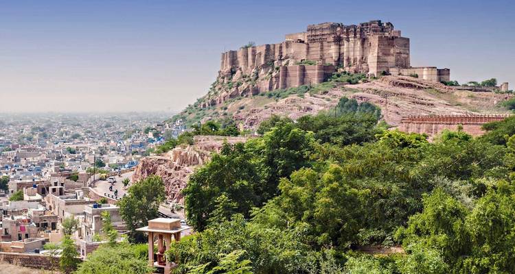 Hilltop Mehrangarh Fort overlooking the blue houses of Jodhpur under a clear blue sky.