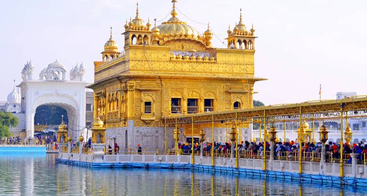 Long queue of worshippers crossing the causeway to the Golden Temple over the sacred pool.