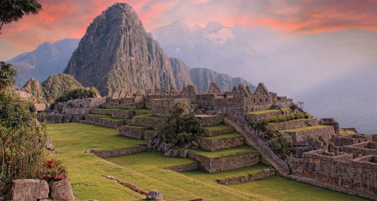 Iconic stone terraces of Machu Picchu beneath a pastel sunrise sky.