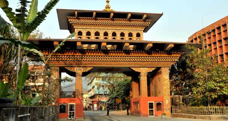 Sierlijke poort in Bhutanese stijl die een weg overspant bij de ingang van een grensstad