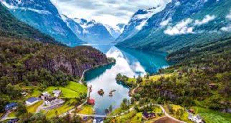 Valle de fiordo noruego vibrante con aguas cristalinas como un espejo, picos nevados y pueblitos dispersos.