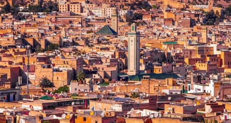 Vue surélevée de la médina historique dense avec des minarets et une lumière chaude en fin d'après-midi