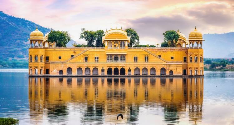 Het gouden Jal Mahal paleis drijft sereen op een spiegelachtig meer bij zonsopgang.