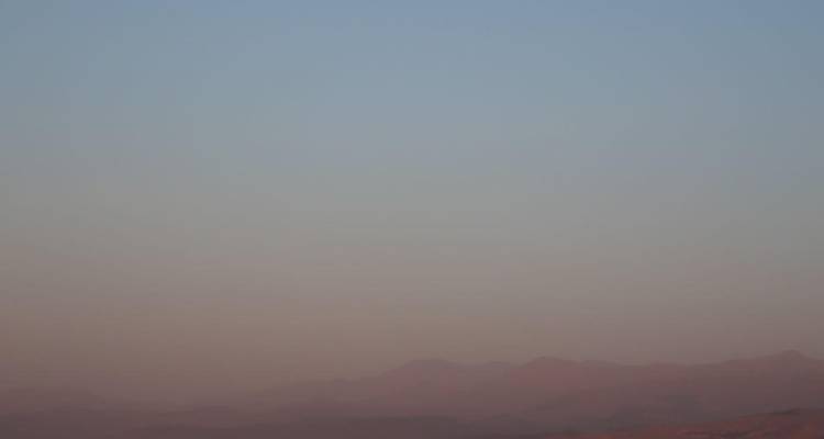 Minimalistische wazig woestijnhorizon met vage bergsilhouetten bij dageraad