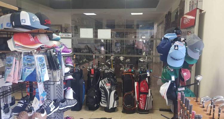 Interieur van een golfpro shop met clubs, tassen, petten en schoenen