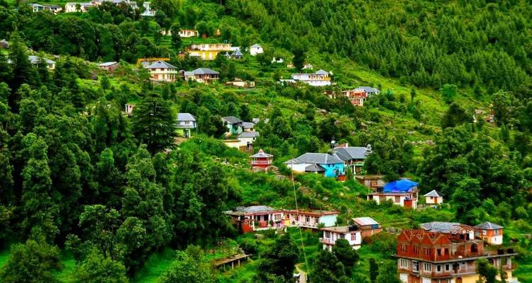 Colorful hillside hamlets nestle among dense evergreen forests on a bright summer day.