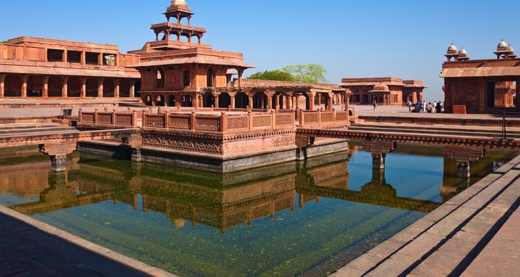 Les cours en grès rouge de l'époque moghole et un bassin rectangulaire reflétant les structures à Fatehpur Sikri.