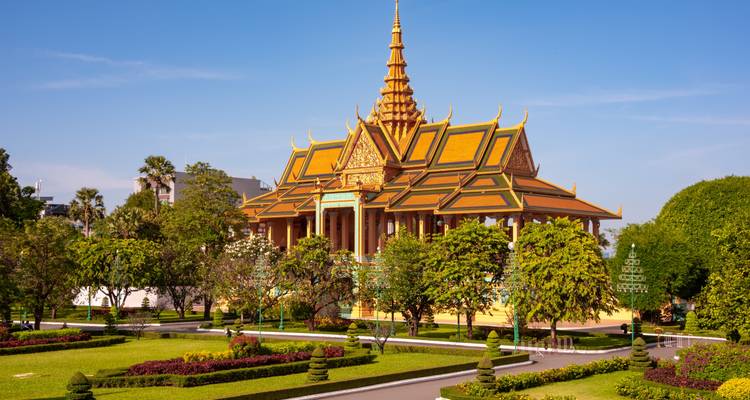 El Palacio Real de techos dorados resplandece entre jardines cuidados bajo un cielo azul claro de Phnom Penh