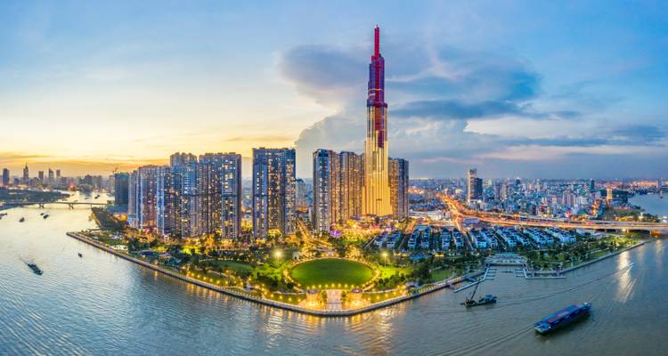 Luftaufnahme der Skyline von Ho-Chi-Minh-Stadt in der Abenddämmerung mit dem Landmark 81, das sich neben dem Saigon-Fluss erhebt