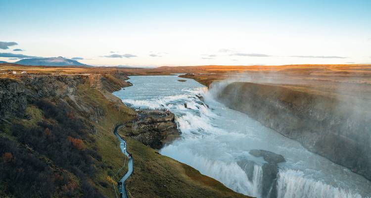 Weids uitzicht op de Gullfoss waterval die bij zonsondergang in een ruige kloof storte met oprijzende nevel