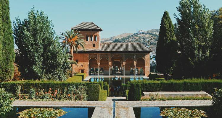 Üppige Wasserbecken und maurische Bögen der Partal-Gärten in Granadas Alhambra