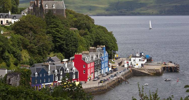 De kleurrijke havenhuizen van Tobermory liggen aan de waterkant omgeven door weelderig groen op het eiland Mull.
